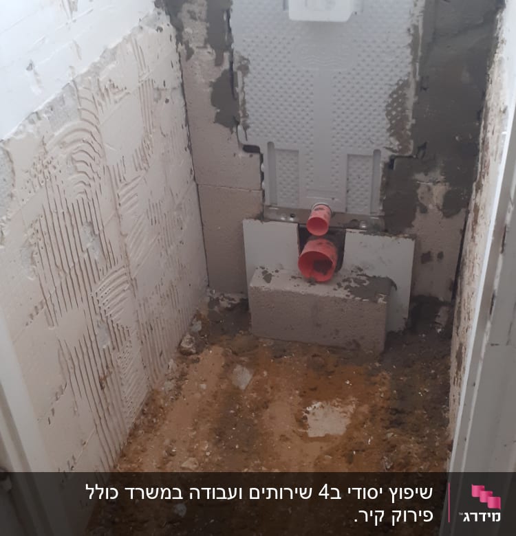 קיר חשוף עם צנרת ושאריות טיח בשיפוץ